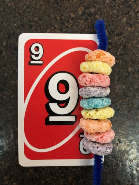 Count how many fruit loops to put on the pipe cleaner! Does it match the Uno Card?
