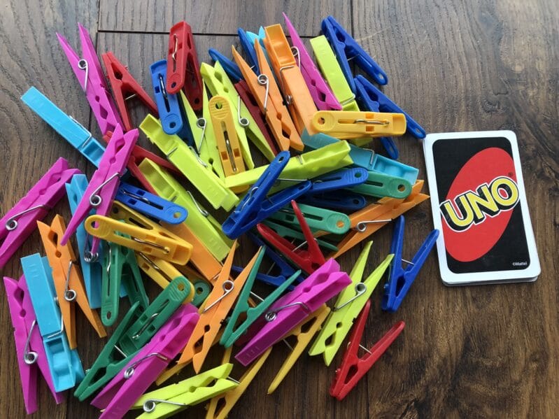 Playing with uno cards and clothespins is a fine motor and counting activity -- and can add in color recognition too! So much learning!