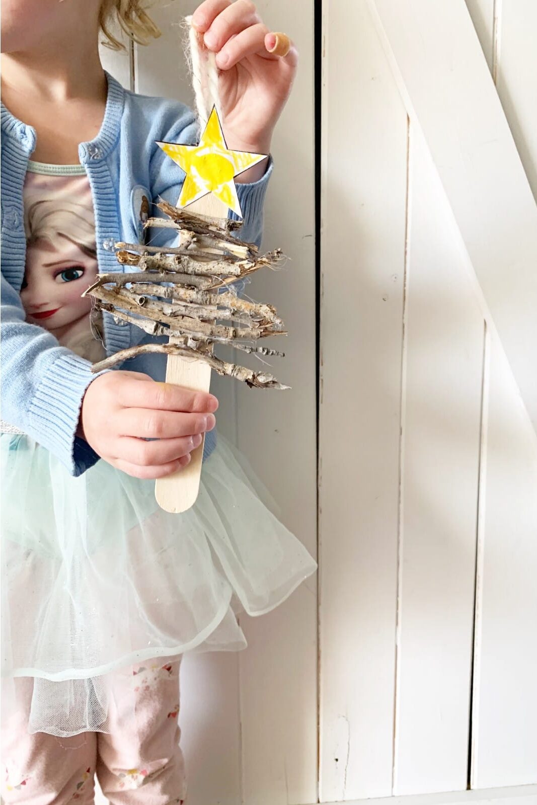This simple DIY stick Christmas tree ornament is an easy rustic hands on gift for your kids to make. Sneak in fine motor and size sorting too!