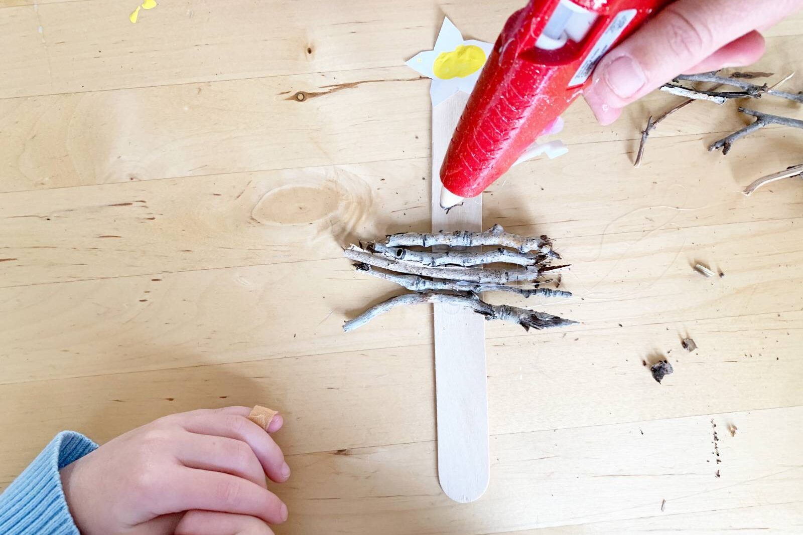 Hot glue sticks in order of size to create a rustic stick tree ornament for Christmas