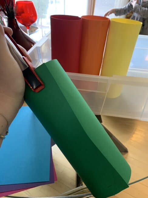 Staple construction paper into colored tubes