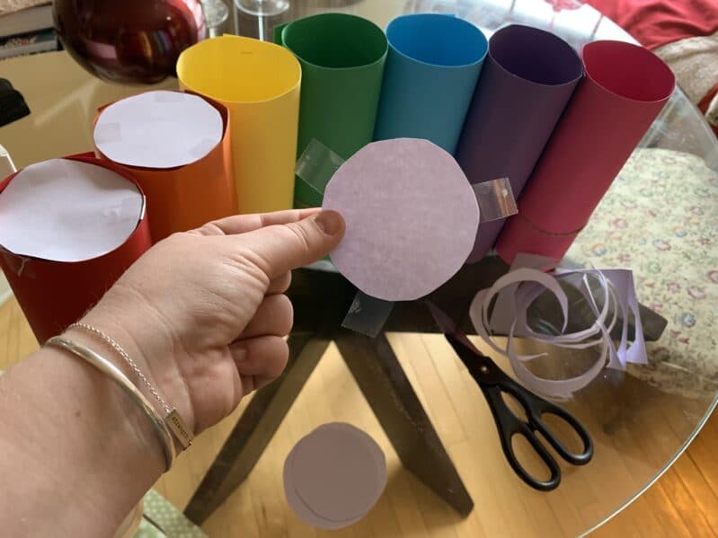 Tape paper circles to the bottom of each paper tube so loose parts don’t fall through.