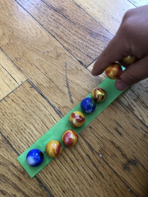 Make patterns with marbles using tape to keep them in place.
