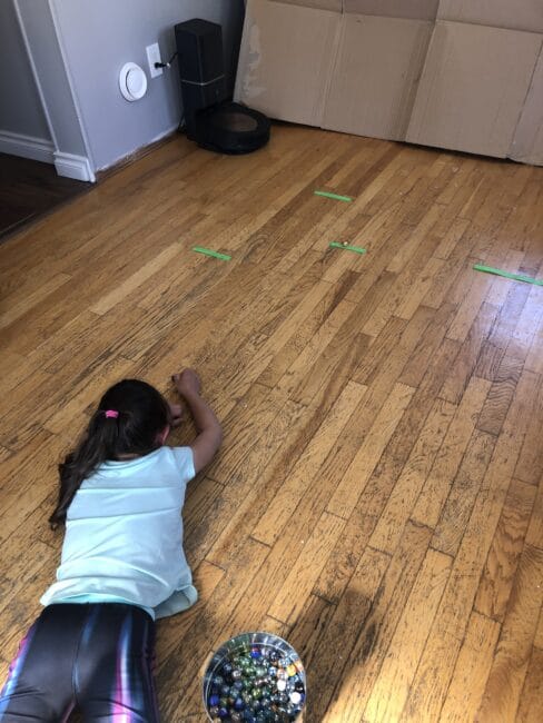 Marble catch game using tape on the floor to stick marbles to.