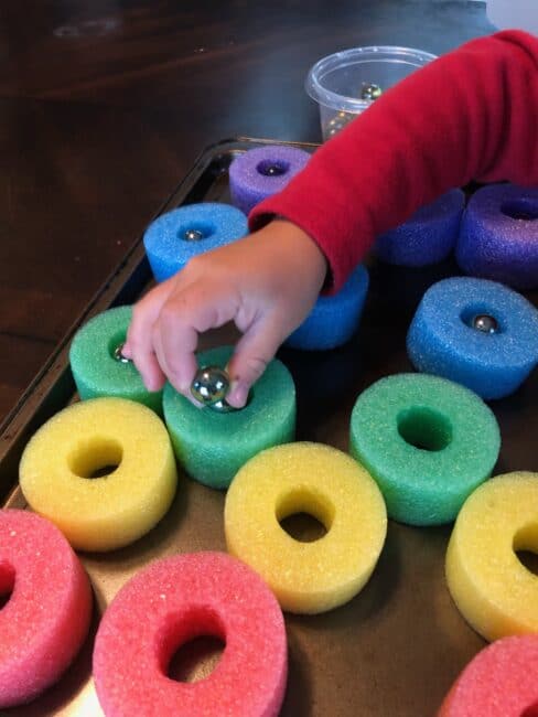 Marble scooping and sorting activity for fine motor pincer grasp and transfer control.