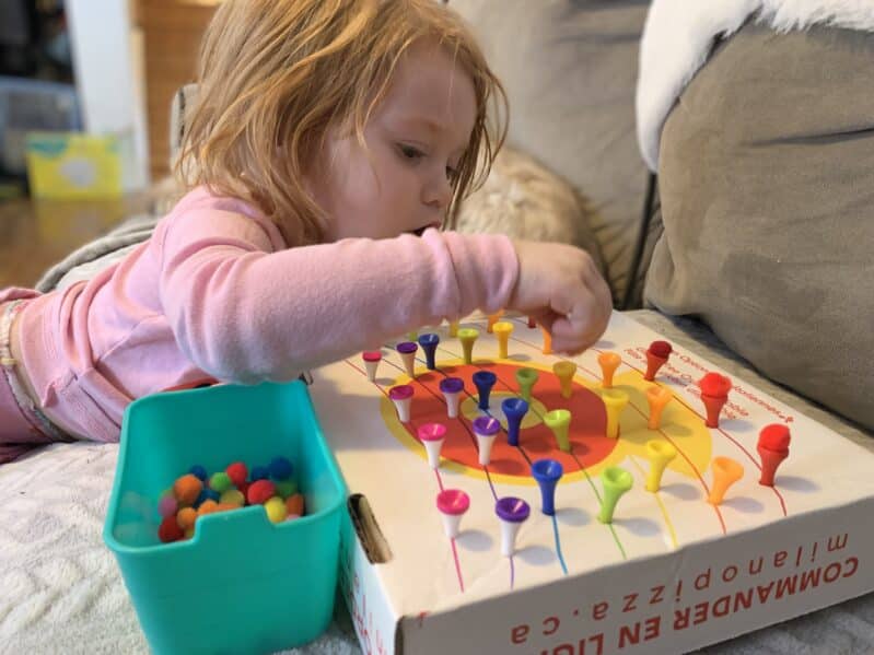 Work on pincer grasp and fine motor muscle control with this fun and simple color matching rainbow that’s all about balancing pom poms on golf tees!