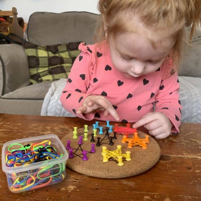 Make a DIY geoboard for toddlers with cork, push pins and rubber hair ties. Create stars, or other simple shapes you are working on learning.