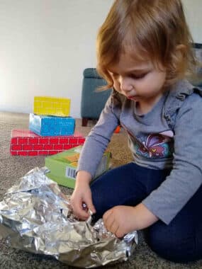 Clara wraps toys with foil