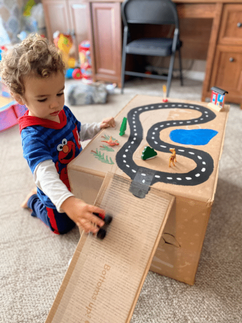 Turn a cardboard box into a magnetic race track as a science lesson on magnetic force & fine motor skills for young kids in just 1 minute.