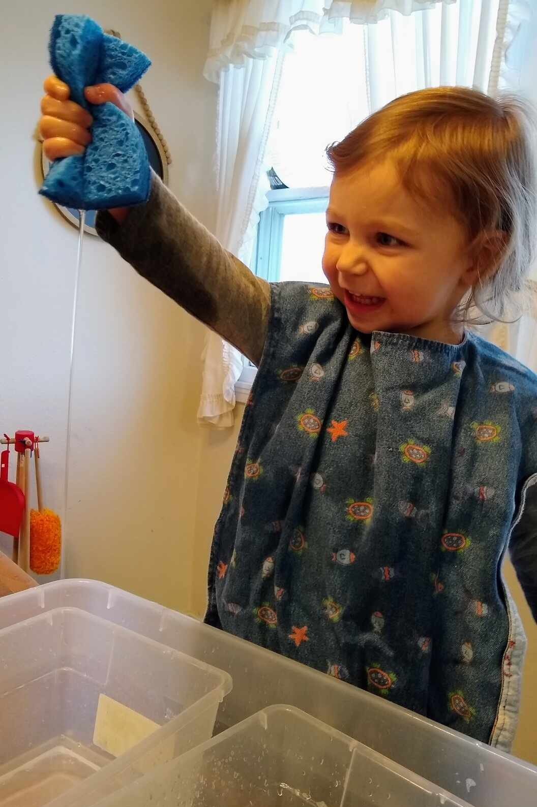 Wringing out sponges is great fine motor play for toddlers and preschoolers to strengthen hand grip muscles by squeezing while enjoying a sensory water transfer activity at home!