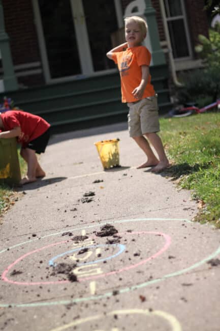 Setting up a simple target practice for preschoolers leads to great gross motor practice with throwing! Why not add some fun playing with mud and getting messy to the mix?