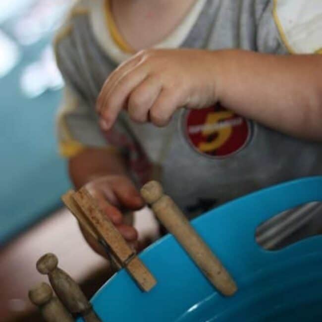 This is a super simple clothespin activity for toddlers to explore and strengthen their fine motor skills.