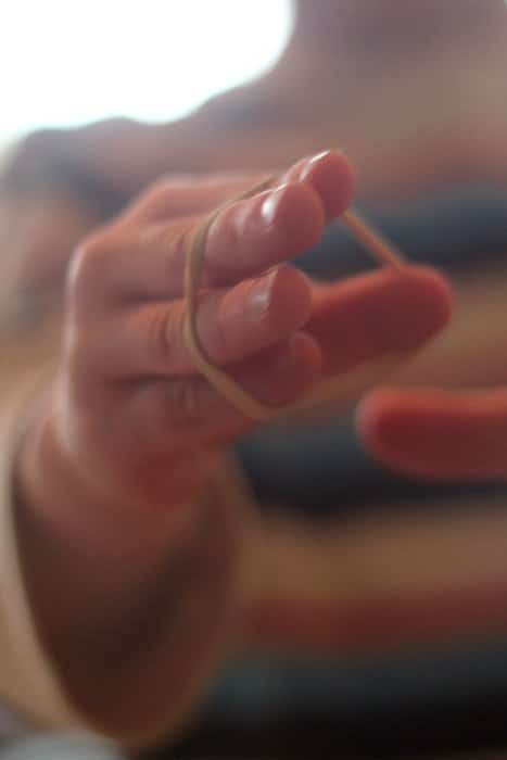 A fine motor activity that focuses on hand strength using rubber bands.