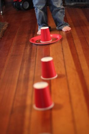 Red cups arranged on the floor for a ring toss game