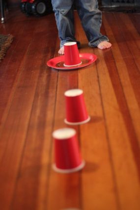 Red cups arranged on the floor for a ring toss game
