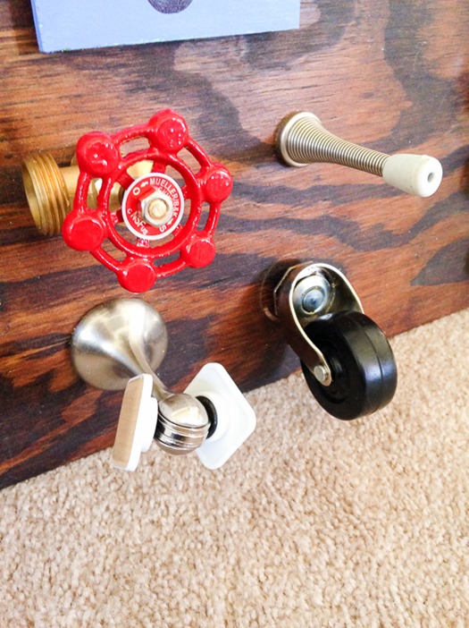 Wheel and magnetic doorstop on toddler busy board