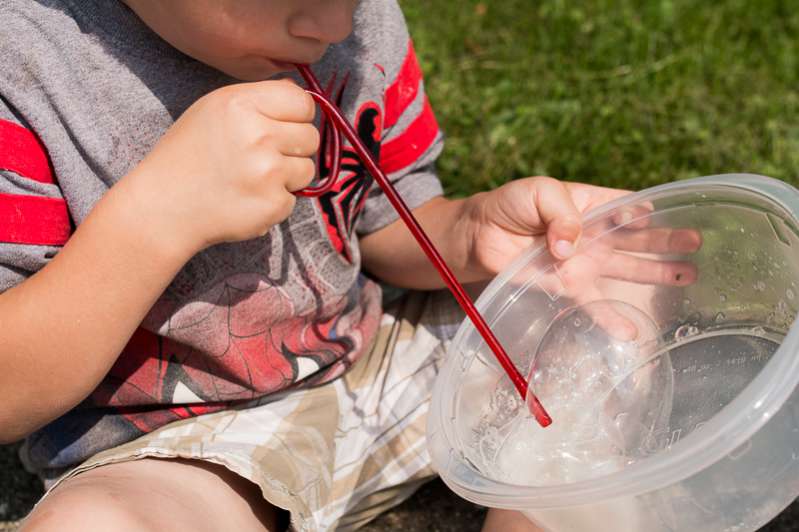 Blowing bubbles with a homemade bubble solution - one of 10 hands-on science & math activities for the kids to LOVE!