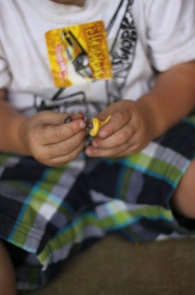 Child's hands threading nuts onto bolts for fine motor practice