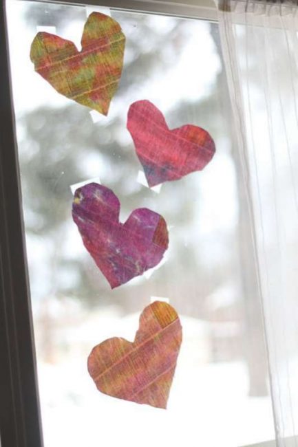 Newsprint watercolor painted hearts to hang on the window for the light to shine through