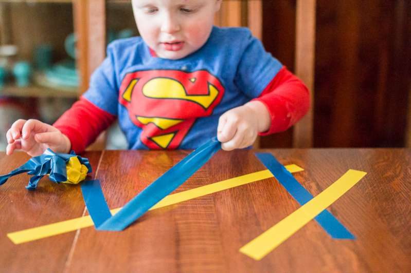 Strengthen tiny toddler fingers with just tape! Try this super simple tape peeling fine motor activity right on the kitchen table at home.