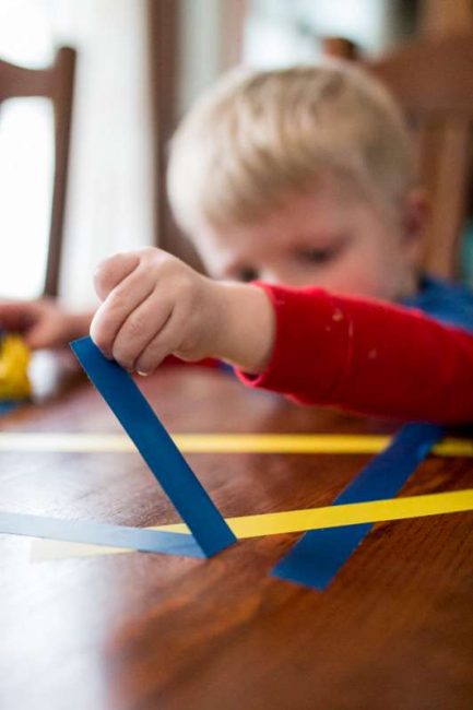 Strengthen tiny toddler fingers with just tape! Try this super simple tape peeling fine motor activity right on the kitchen table at home.