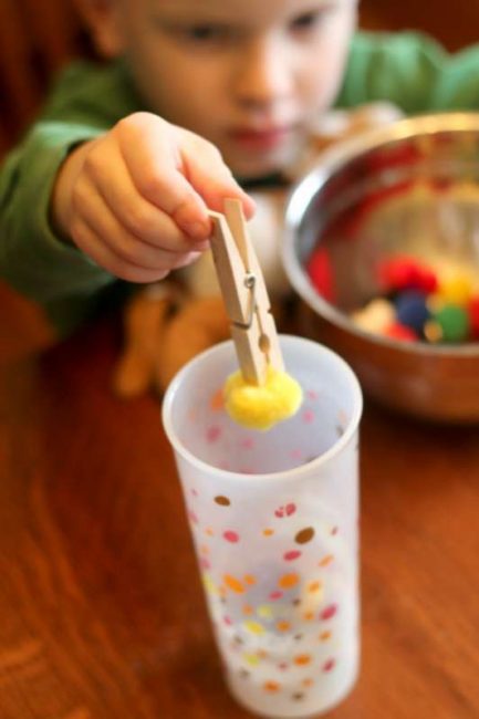 Strengthen preschool fine motor skills using clothespins - aka the "claw grabbing machine"