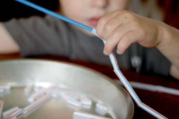 Straws. If you're comfortable with your child having a scissors, hand them some straws with a pair of scissors and let your child cut them up. If not, have straws some already cut up handy with some yarn, or a shoestring, and thread away.