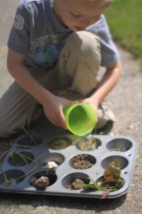 Child pouring water into a muffin tin of materials to test absorption